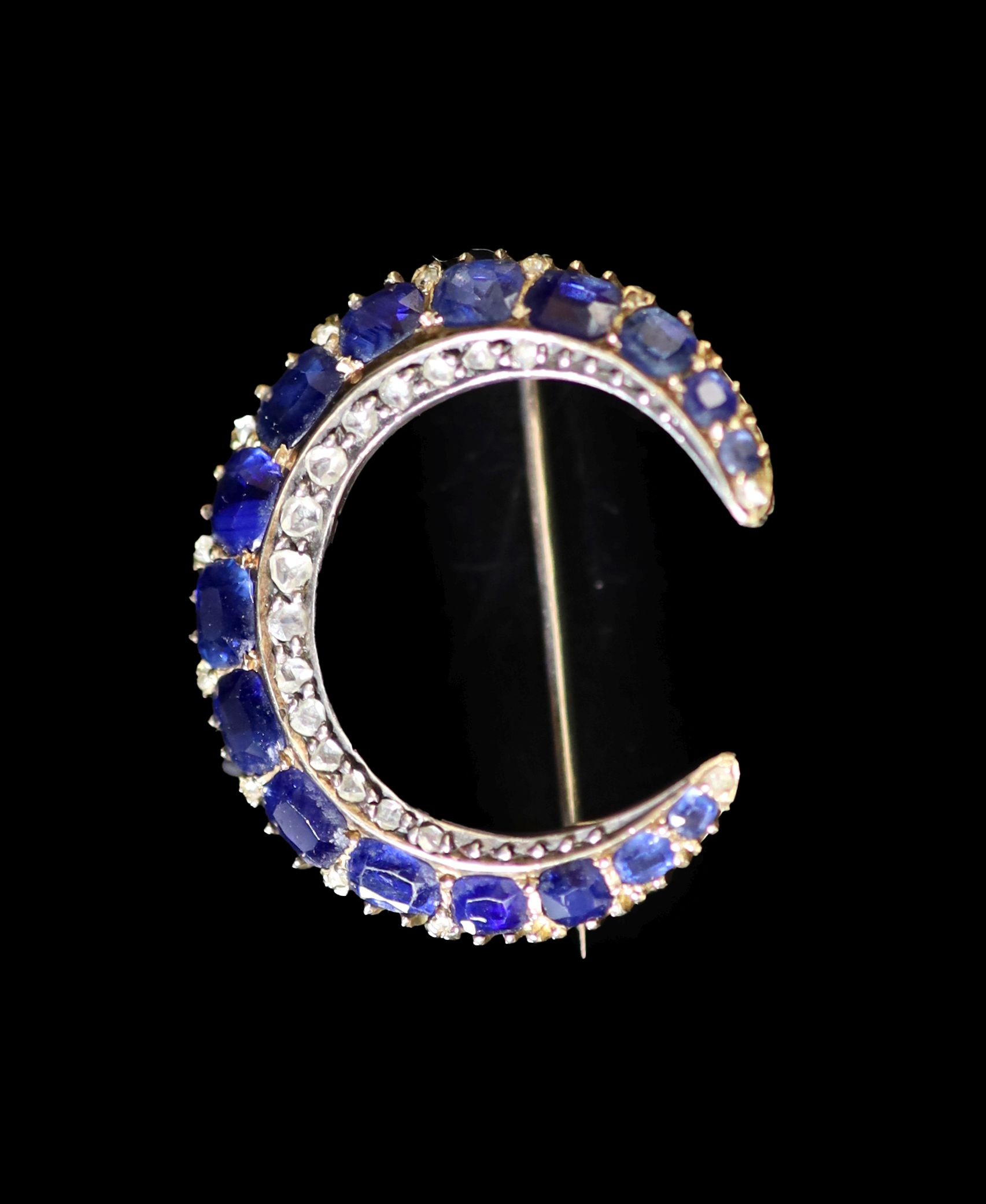 An early 20th century gold, graduated sapphire and rose cut diamond set crescent brooch